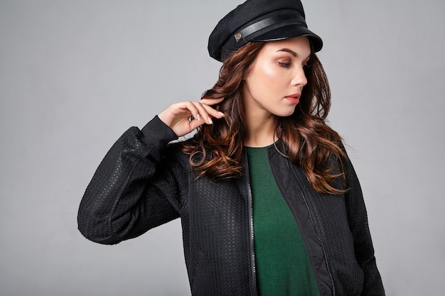 Foto gratuita retrato de joven modelo elegante riendo en ropa casual de verano negro en gorra con maquillaje natural en gris