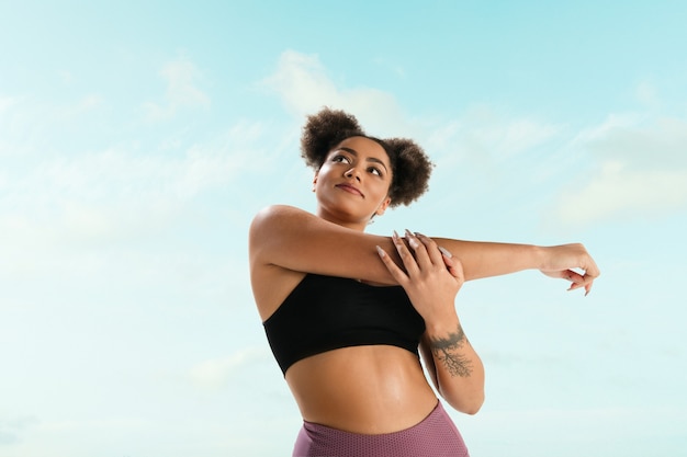 Retrato de joven modelo de moda femenina sobre fondo de cielo azul.