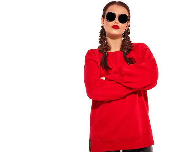 Foto gratuita retrato de joven modelo de mujer sonriente feliz con maquillaje brillante y labios coloridos con dos coletas y gafas de sol en ropa de verano rojo aislado. brazos cruzados