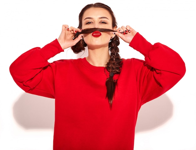 Foto gratuita retrato de joven modelo de mujer sonriente feliz con maquillaje brillante y labios coloridos con dos coletas y gafas de sol en ropa de verano rojo aislado. hacer bigote simulado usando su propio cabello