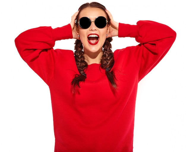 Foto gratuita retrato de joven modelo de mujer sonriente feliz con maquillaje brillante y labios coloridos con dos coletas y gafas de sol en ropa de verano rojo aislado.