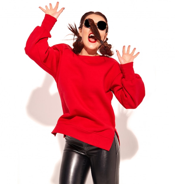 Retrato de joven modelo de mujer sonriente feliz con maquillaje brillante y labios coloridos con dos coletas y gafas de sol en ropa de verano rojo aislado.