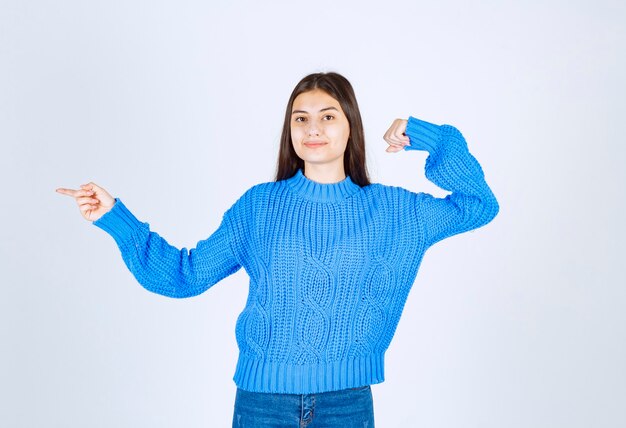 Foto gratuita retrato de una joven modelo de pie y apuntando hacia afuera.