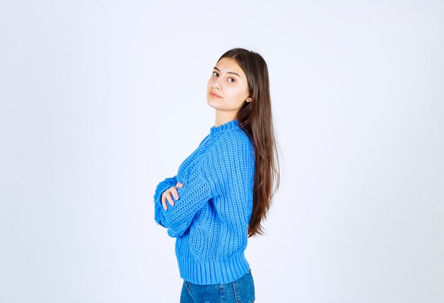 Retrato de una joven modelo de pie con las manos cruzadas y mirando hacia adelante.