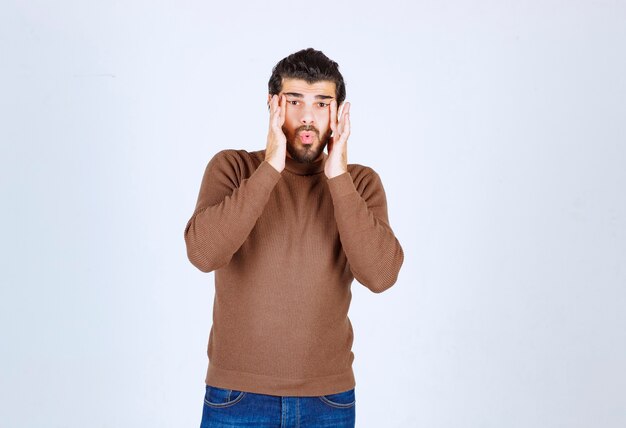 Retrato de un joven modelo de pie y mirando atentamente. Foto de alta calidad