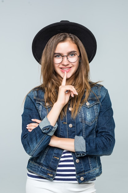 Foto gratuita retrato joven mostrando gesto de silencio sobre fondo gris