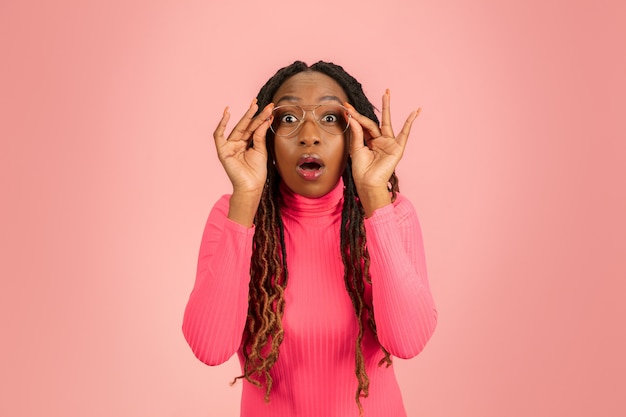 Retrato de joven mujer afroamericana aislado sobre fondo rosa.