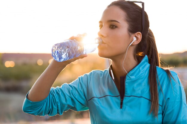 Retrato de joven mujer de agua potable después de correr.