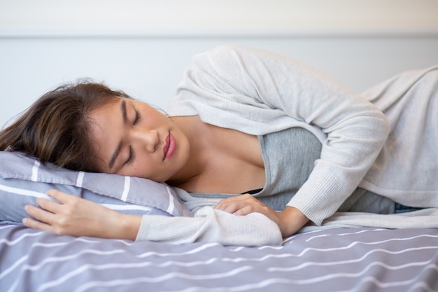 Retrato de joven mujer asiática durmiendo en la cama