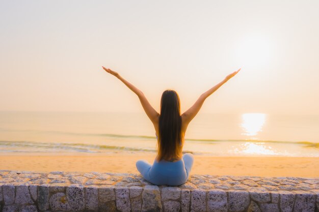 Retrato joven mujer asiática hacer meditación alrededor del mar playa océano al amanecer