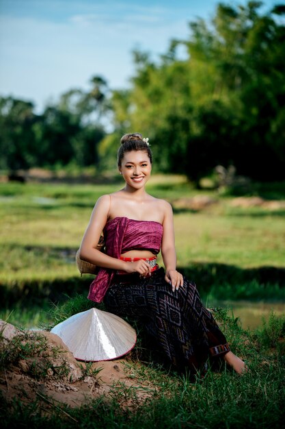 Retrato joven mujer asiática en hermosas ropas tradicionales tailandesas en el campo de arroz