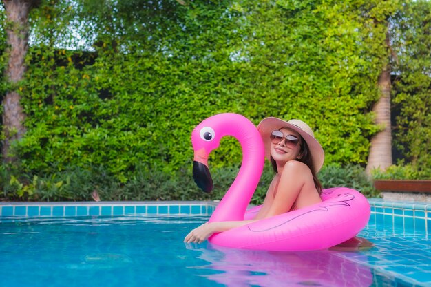 Retrato joven mujer asiática relajarse feliz sonrisa alrededor de la piscina en el hotel