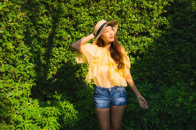 Retrato joven mujer asiática sonrisa feliz relajarse alrededor del jardín de la naturaleza al aire libre