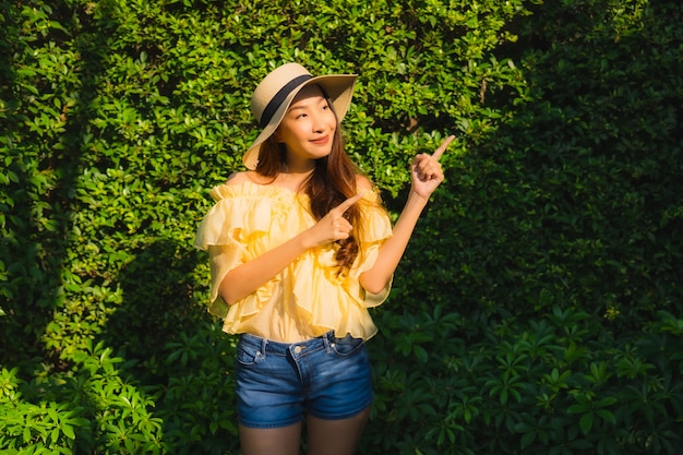 Retrato joven mujer asiática sonrisa feliz relajarse alrededor de jardín de naturaleza al aire libre