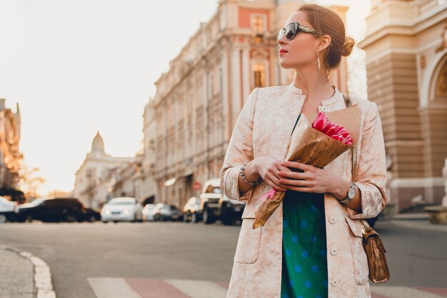 Retrato de joven mujer atractiva elegante caminando en la ciudad