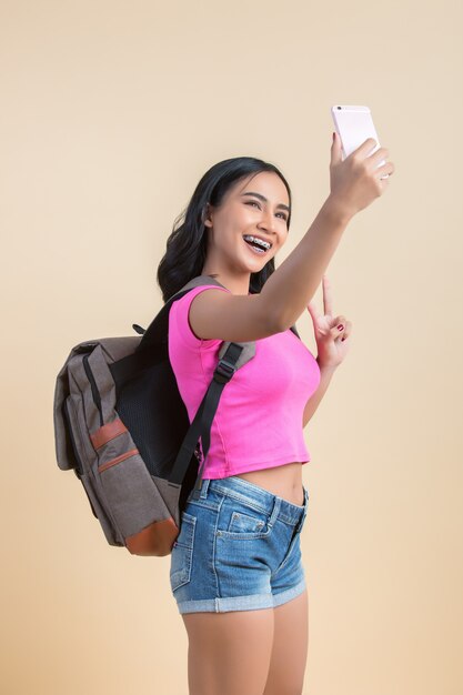 Retrato de una joven mujer atractiva haciendo selfie foto con smartphone