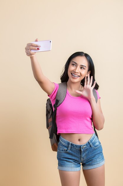 Retrato de una joven mujer atractiva haciendo selfie foto con smartphone