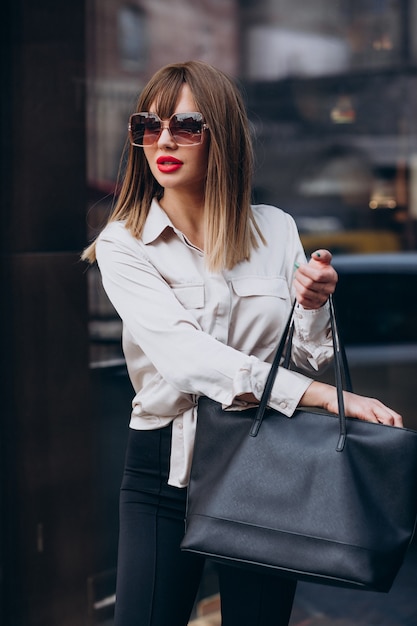 Retrato de joven mujer atractiva modelo mirando en su bolso