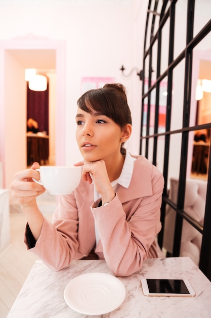 Retrato de una joven mujer atractiva con taza de café