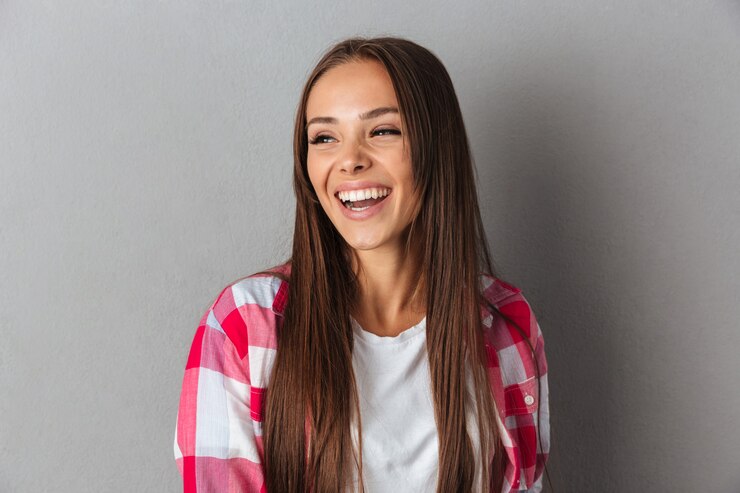 Foto gratuito retrato de una joven mujer bonita en camisa a cuadros riendo