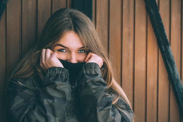 Retrato joven mujer bonita en invierno en una cabaña de troncos en la nieve.