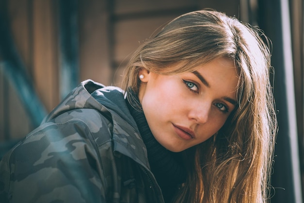 Retrato joven mujer bonita en invierno en una cabaña de troncos en la nieve.