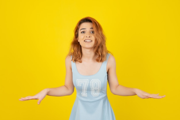 Retrato de joven mujer bonita en pared amarilla de cerca