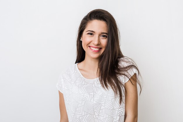 Retrato de joven mujer bonita sonriendo en camiseta blanca, feliz, estado de ánimo positivo, sonrisa aislada, sincera, cabello largo