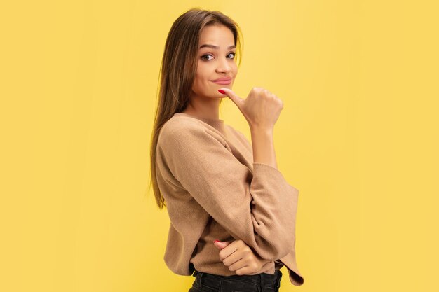 Retrato de joven mujer caucásica con emociones brillantes aisladas en amarillo