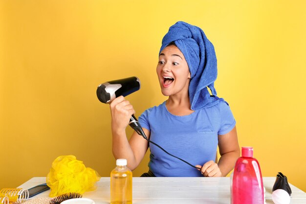 Retrato de joven mujer caucásica en su rutina de belleza día, piel y cuidado del cabello. Modelo de mujer con cosmética natural aplicando cremas y aceites de maquillaje. Cuidado corporal y facial, concepto de belleza natural.