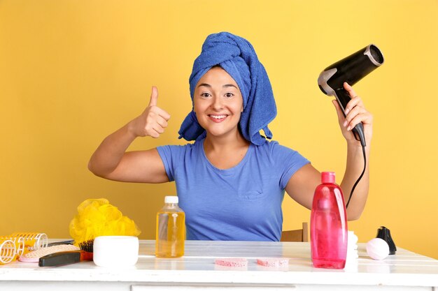 Retrato de joven mujer caucásica en su rutina de belleza día, piel y cuidado del cabello. Modelo de mujer con cosmética natural aplicando cremas y aceites de maquillaje. Cuidado corporal y facial, concepto de belleza natural.