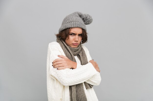 Retrato de una joven mujer congelada en bufanda y sombrero