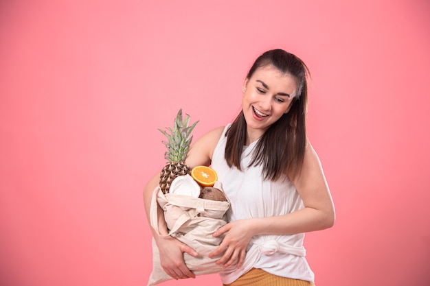 Retrato de una joven mujer elegante con una bolsa de eco-fruta.