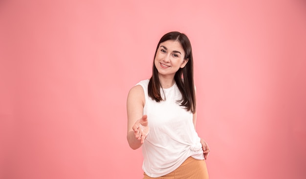 Retrato de una joven mujer elegante que extiende su mano para saludar