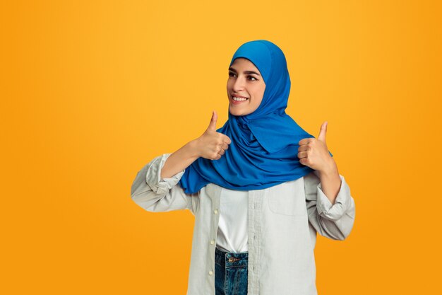 Retrato de joven mujer musulmana aislada sobre fondo amarillo studio