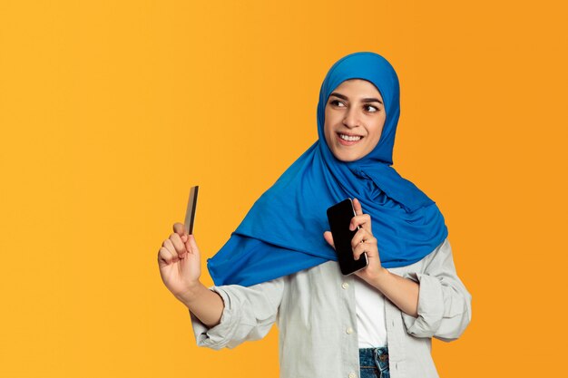 Retrato de joven mujer musulmana aislada sobre fondo amarillo studio