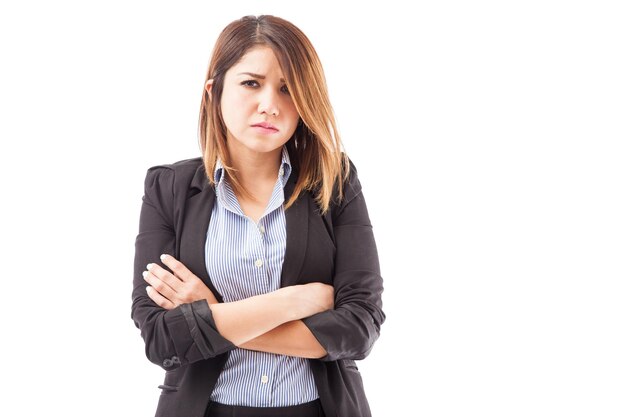 retrato, de, un, joven, mujer de negocios, con, armamentos cruzaron, mirar, molesto, contra, un, fondo blanco