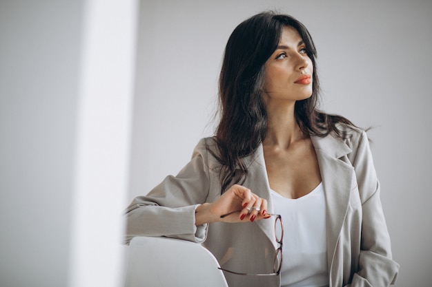 Foto gratuita retrato de una joven mujer de negocios sentado en la oficina