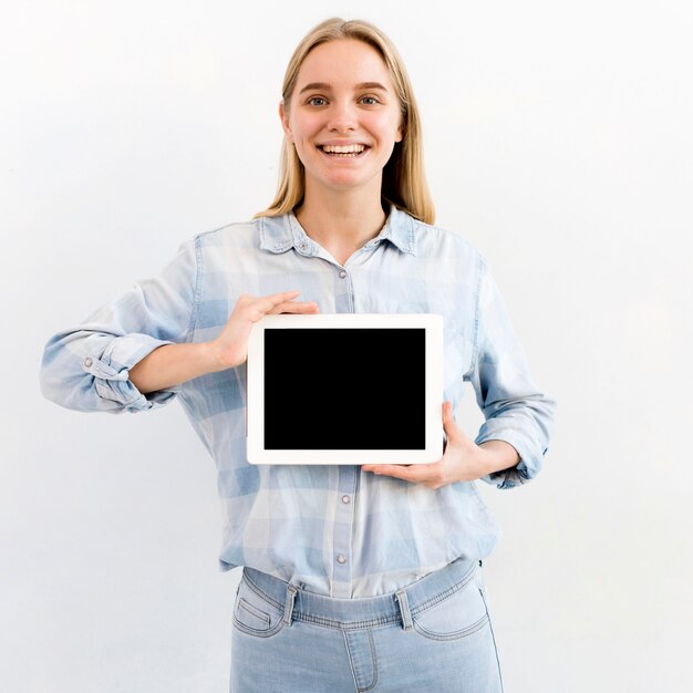 Retrato de joven mujer rubia sosteniendo una tableta