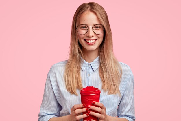 Retrato de joven mujer rubia sosteniendo una taza de café