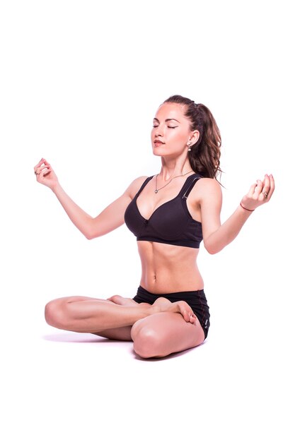 Retrato de una joven mujer sana haciendo ejercicios de yoga, aislado sobre fondo blanco.