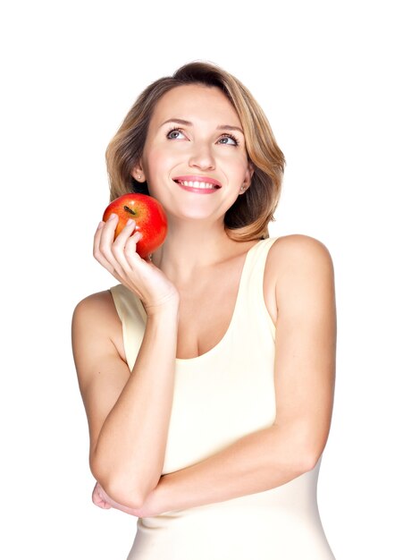 Retrato de una joven mujer sana sonriente con manzana roja aislada en blanco.