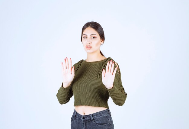 Retrato de una joven mujer seria modelo levantando las manos y posando.