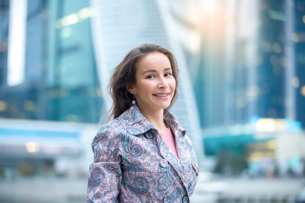 Retrato de una joven mujer sonriente en la calle de la ciudad