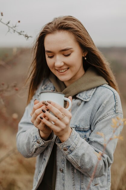 Retrato joven mujer sosteniendo la taza con té