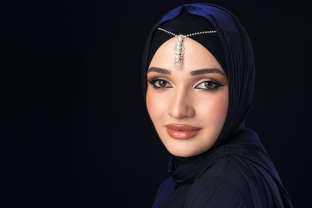 Retrato de una joven musulmana en hijab sobre fondo negro