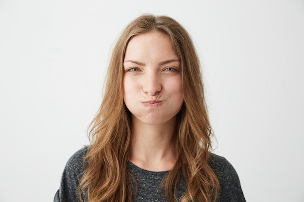 Retrato de joven muy ofendido con cara divertida frunciendo el ceño.