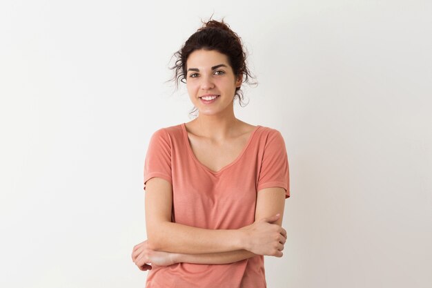 Retrato de joven natural sonriente feliz hipster mujer bonita en camisa rosa posando aislado sobre fondo blanco de estudio