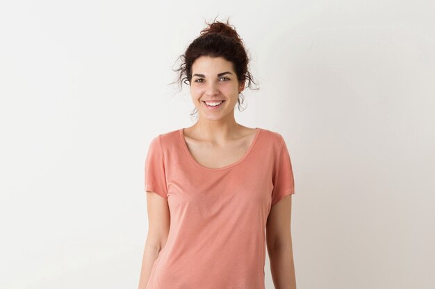 Retrato de joven natural sonriente feliz hipster mujer bonita en camisa rosa posando aislado sobre fondo blanco de estudio