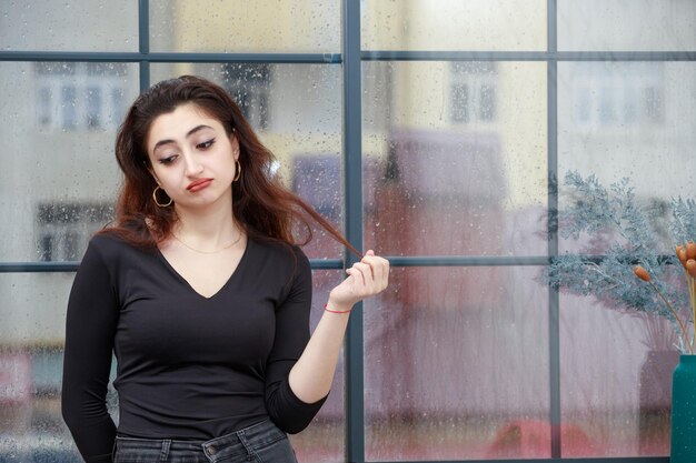 Un retrato de una joven se para y parece triste Foto de alta calidad